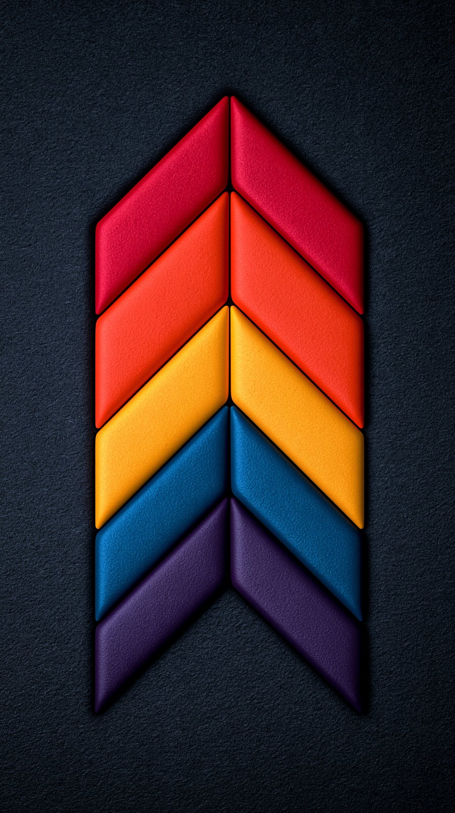 A vertical arrow-shaped stack of soft padded chevron segments in red, orange, yellow, blue, and purple on a dark textured background.